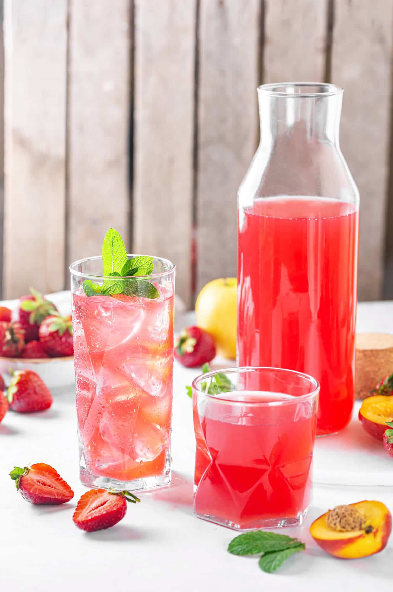 fruit-juice-in-glasses-with-fruits-scattered-around-and-a-glass-jar-with-more-juice