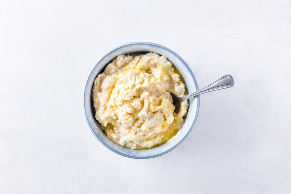 Sweet cheese filling for Russian vatrushka buns in a bowl with a spoon.