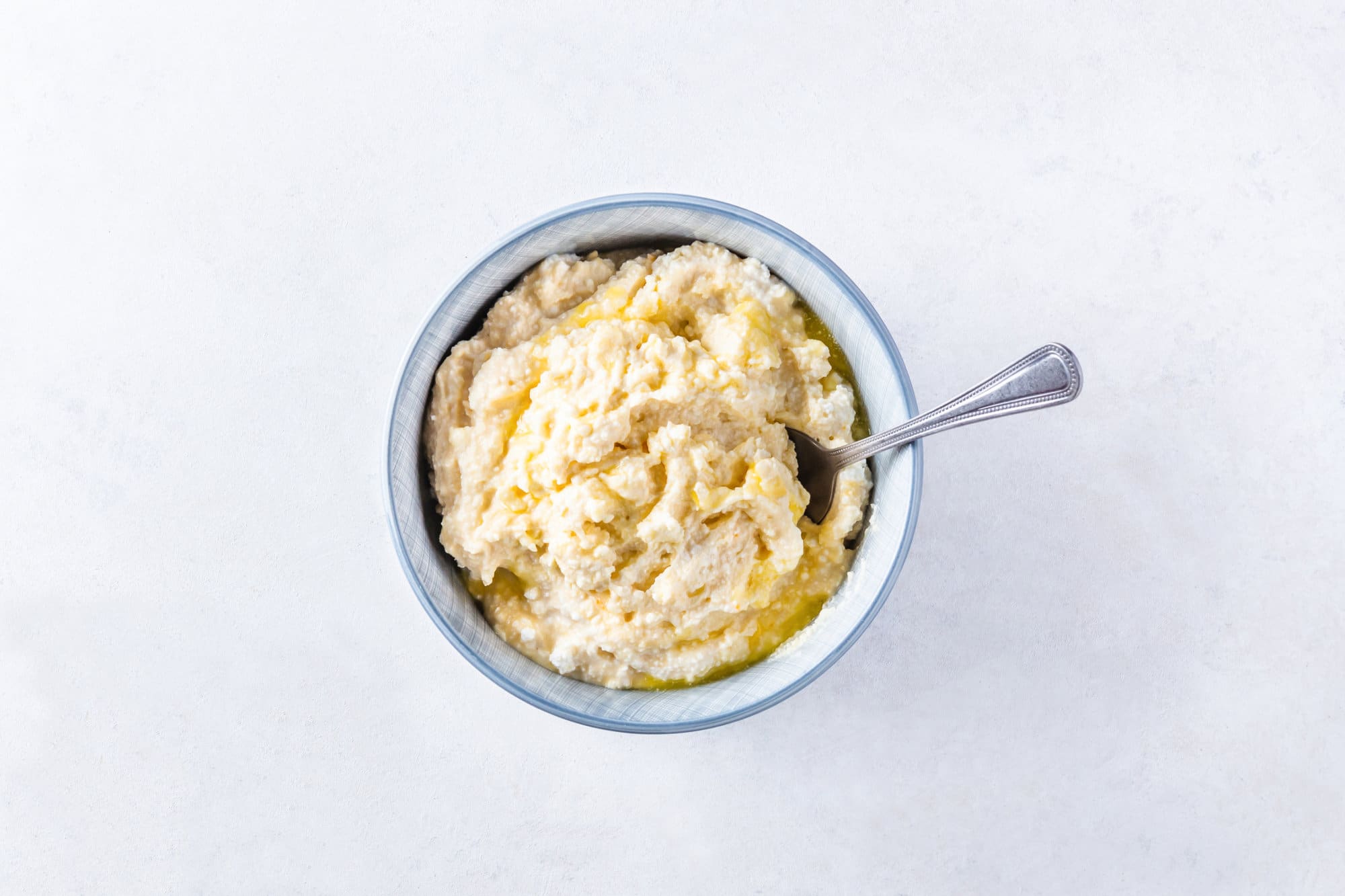 Sweet cheese filling for Russian vatrushka buns in a bowl with a spoon.