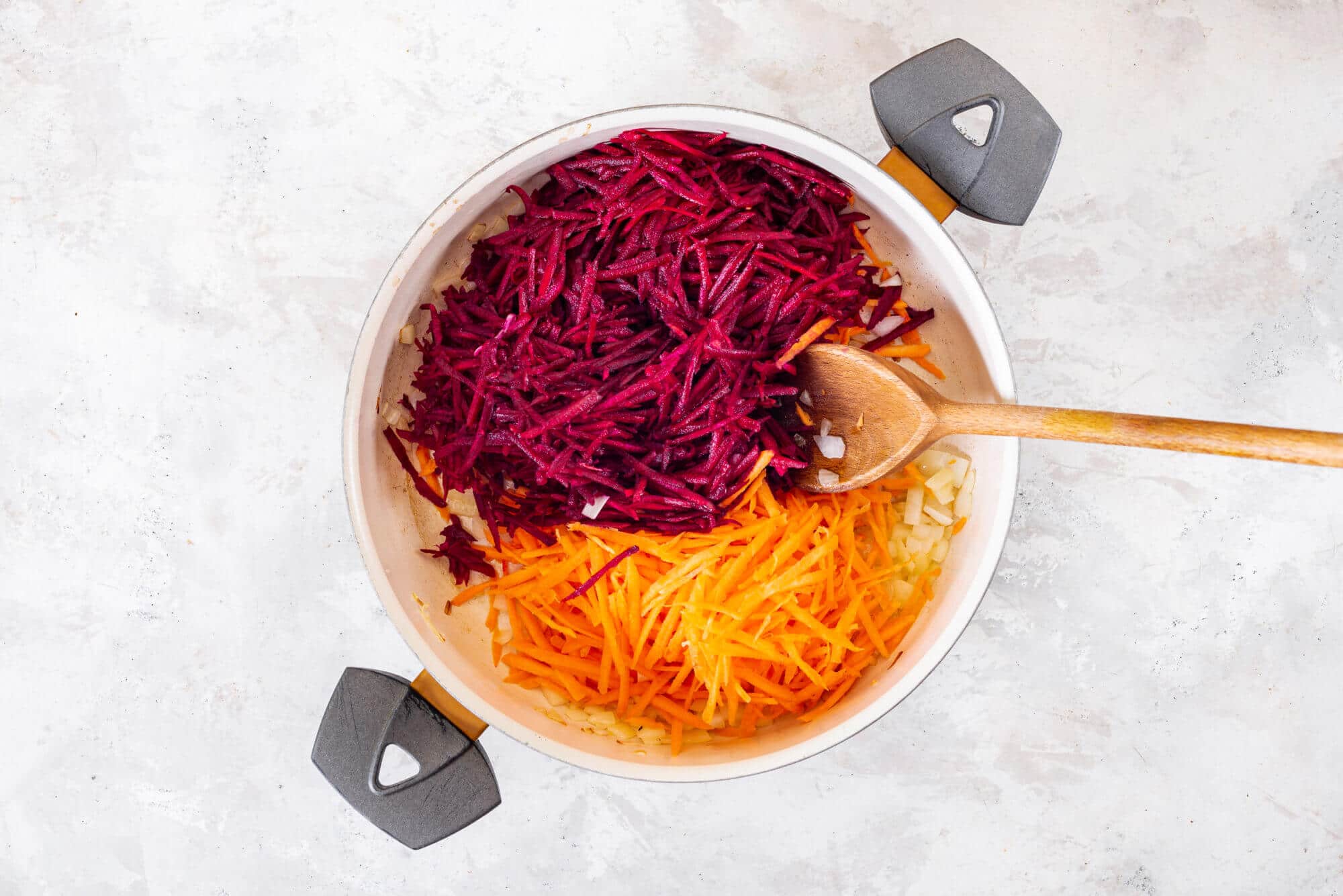 carrots-beets-and-onion-sauteing-in-a-skillet-with-a-wooden-spoon