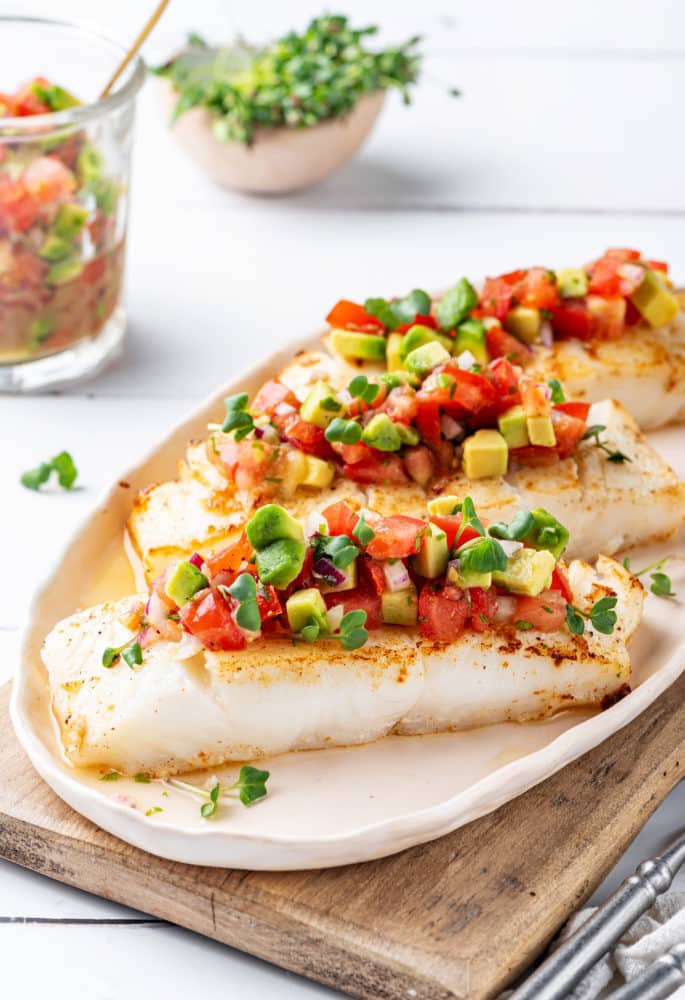 halibut-with-salsa-on-a-white-plate-on-a-wooden-board