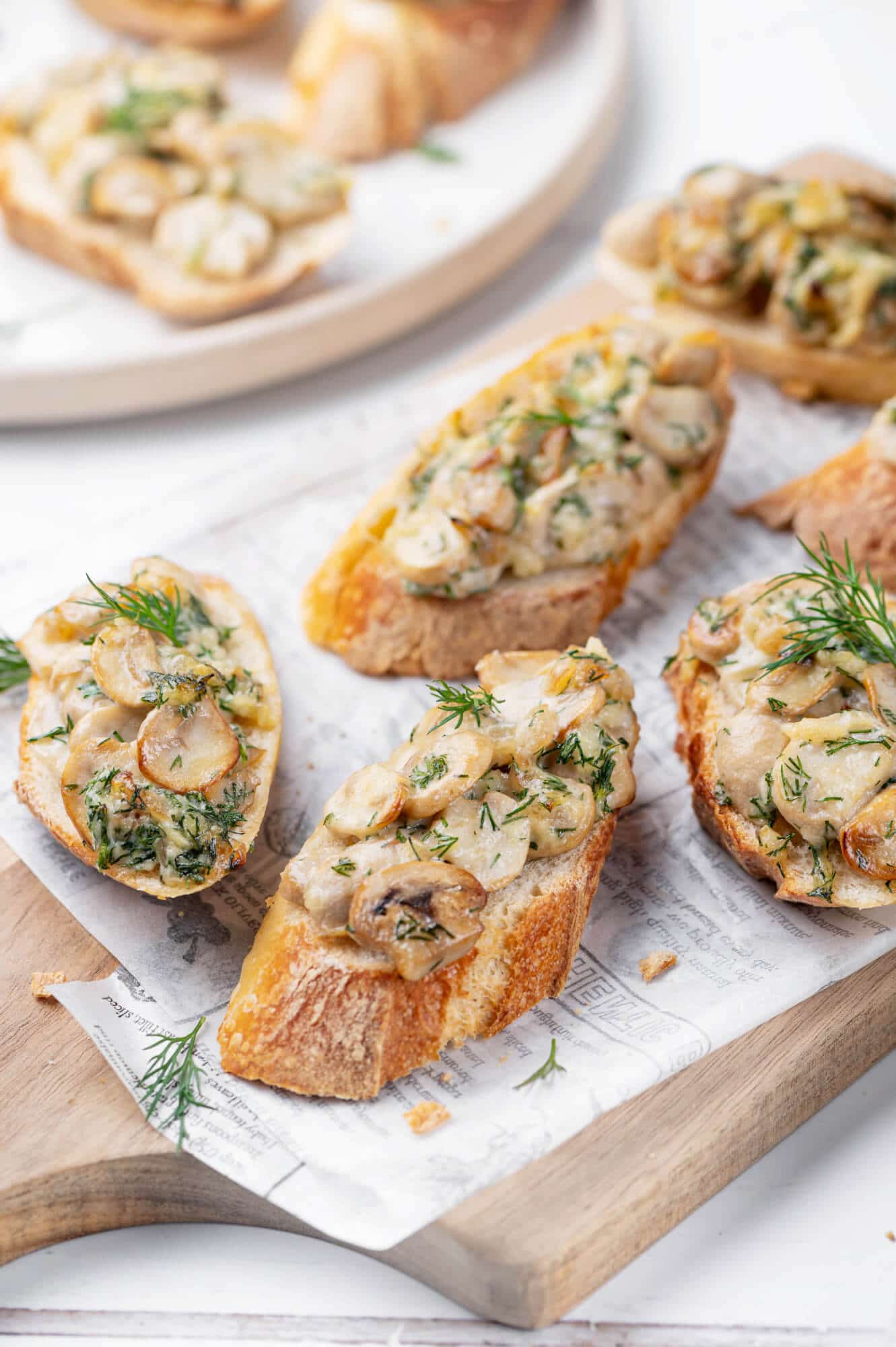 mushroom-crostini-on-wooden-cutting-board-with-paper