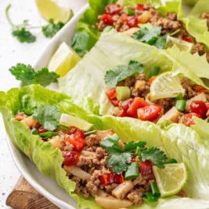 Lettuce wraps with turkey filling on a white plate.