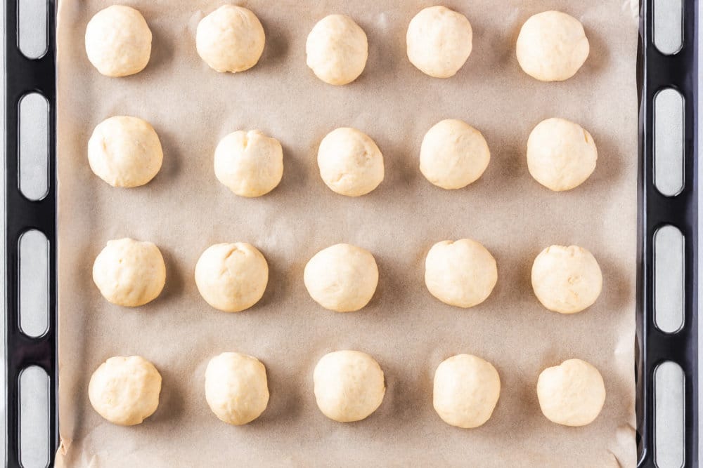 Dough for Russian sweet vatrushka buns on a baking sheet.