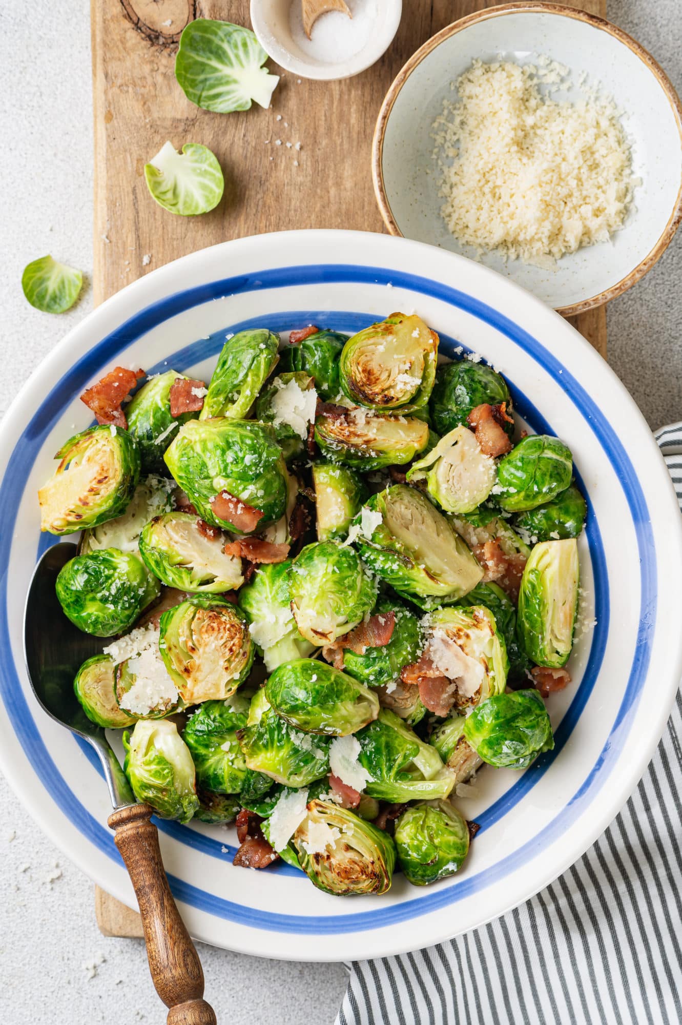 a blue and white bowl with brussels sprouts and bacon in it.