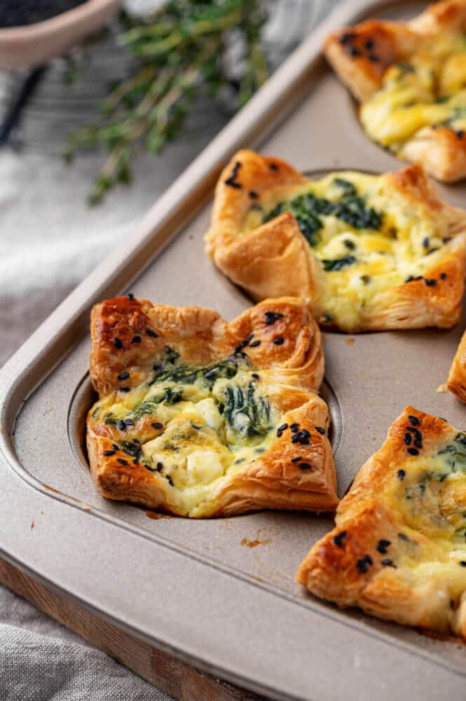 spinach puffs in a muffin tray on a towel.