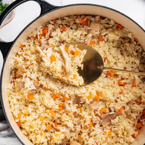 Rice pilaf on a pot with a large spoon.