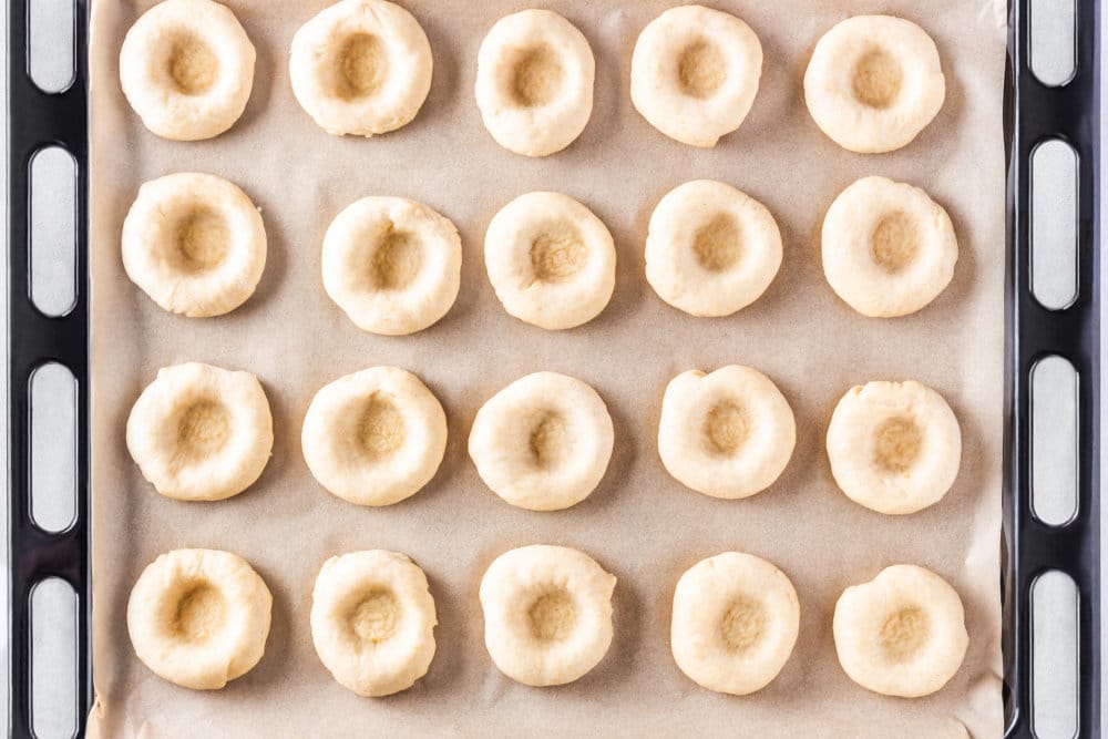 Russian vatrushka bun dough on a baking tray.