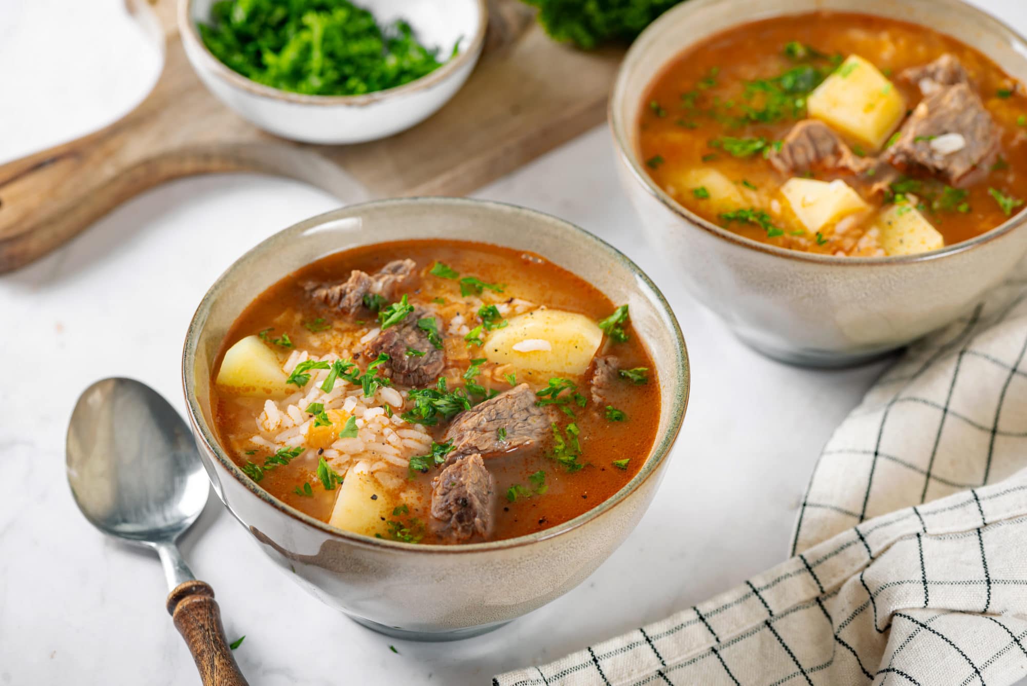 beef-soup-in-beige-bowls-with-a-spoon