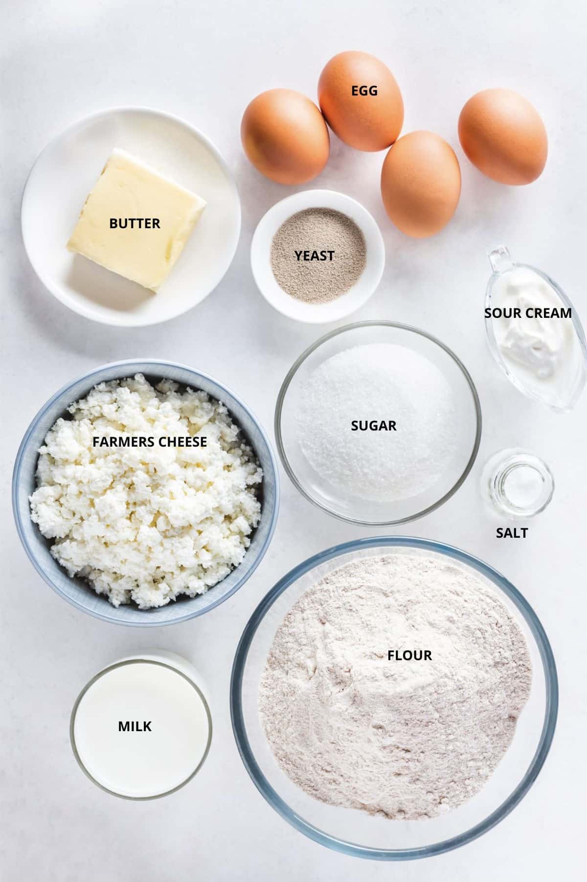Russian sweet cheese filling vatrushka buns ingredients with labels eggs yeast butter sugar sour cream salt farmers cheese milk and flour.