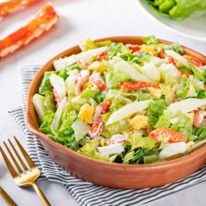 Crab and apple salad with a gold fork and spoon on the side.