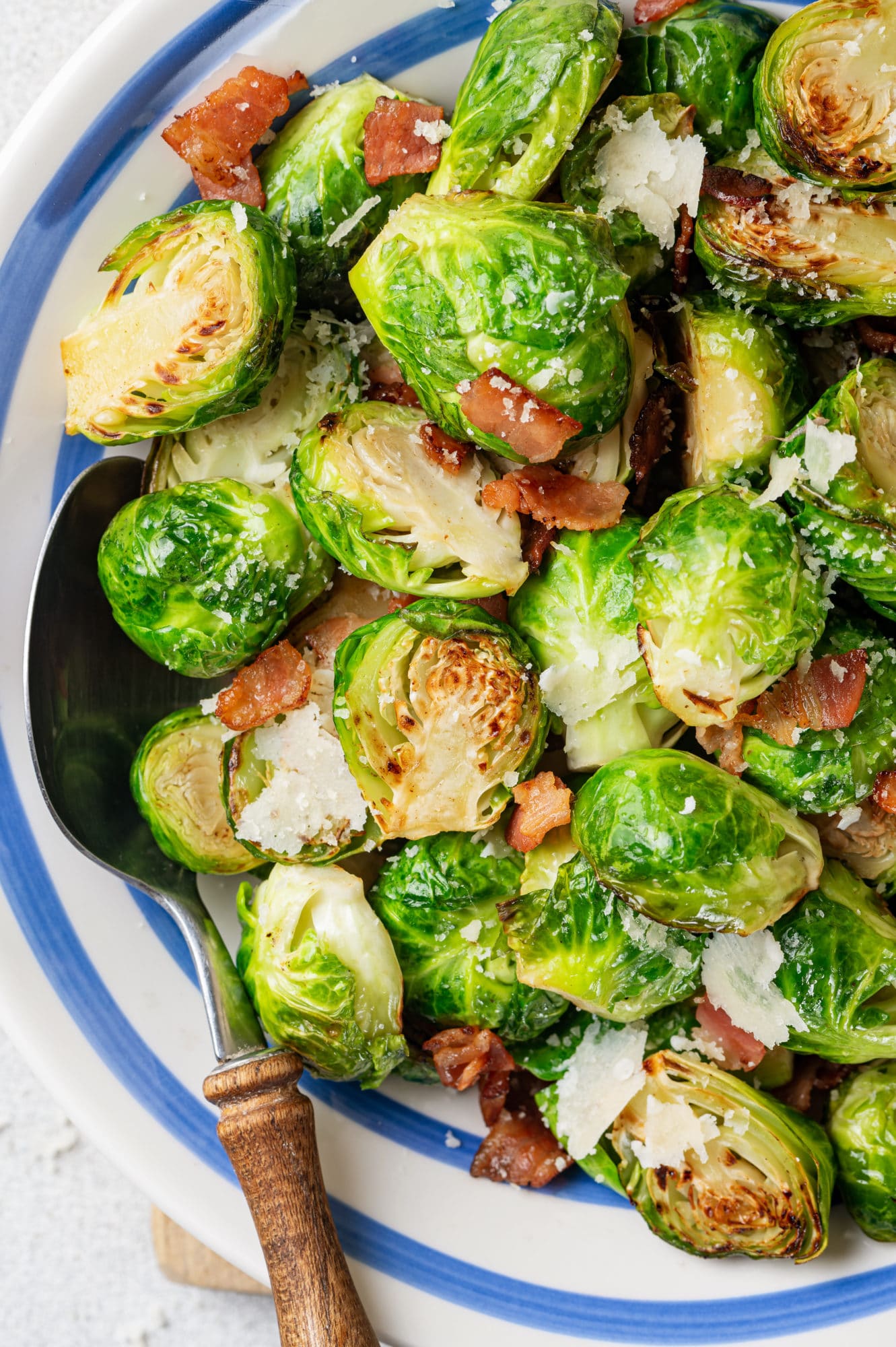 close up of a white bowl with brussels sprouts and bacon in it.