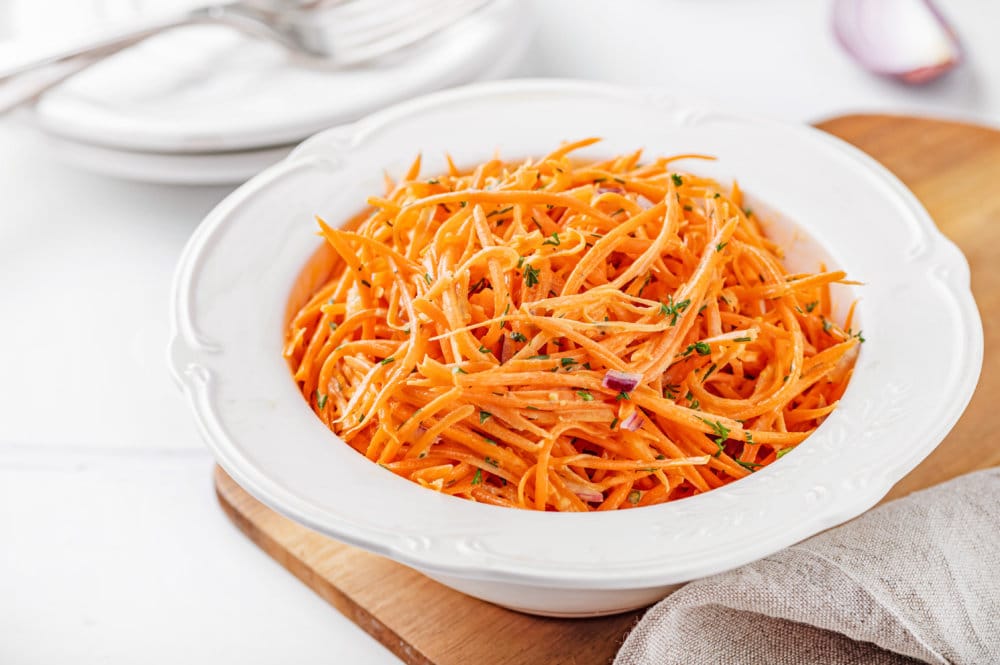 carrot-salad-in-a-white-bowl-on-a-wooden-board