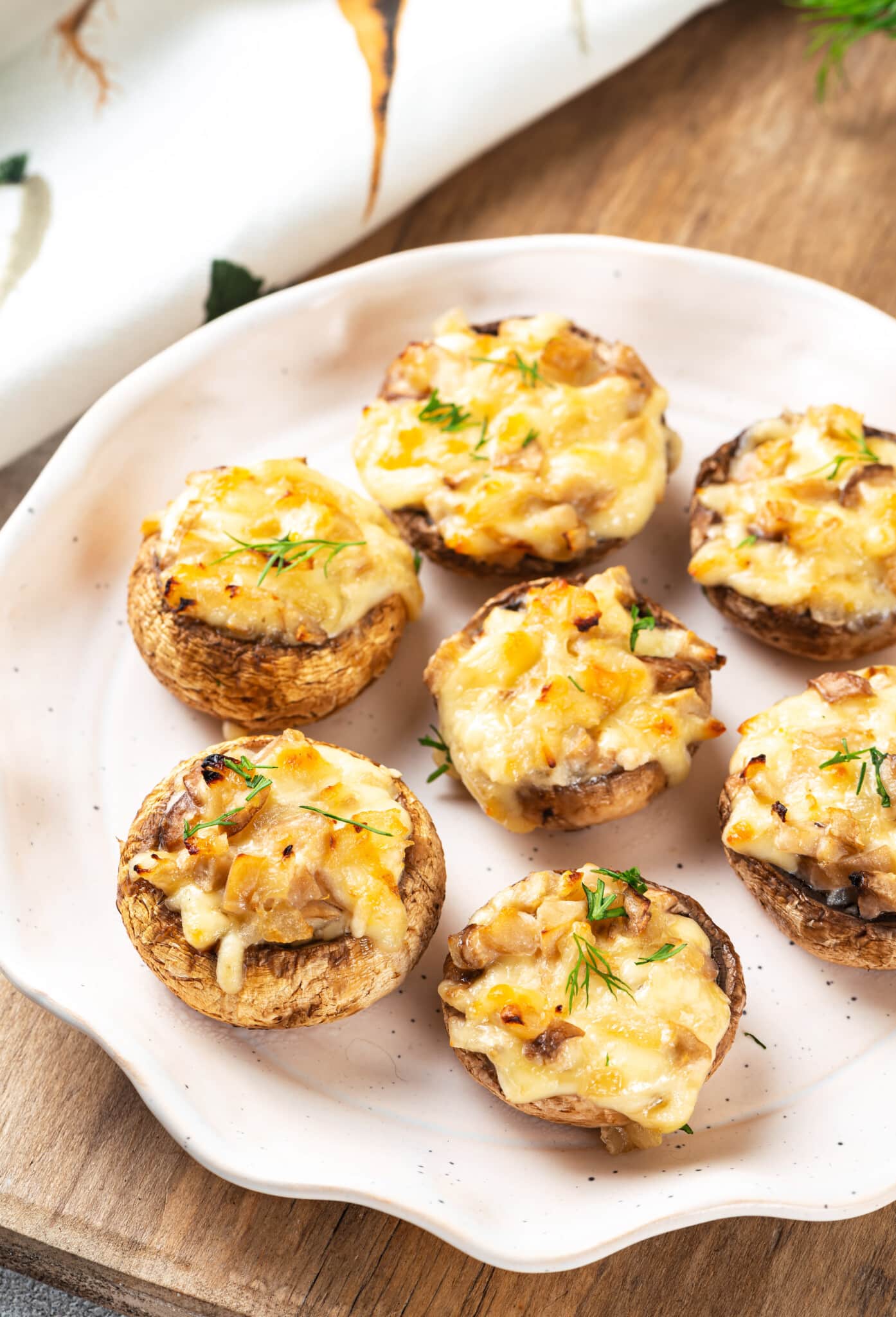 A plate of baked and stuffed mushroom caps.