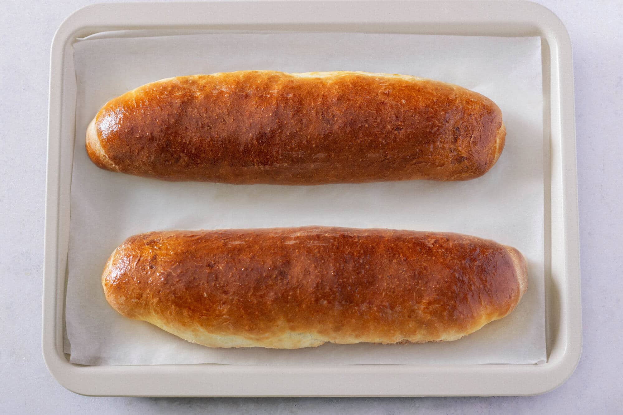 baked-walnut-roll-on-parchment-paper-and-a-baking-tray