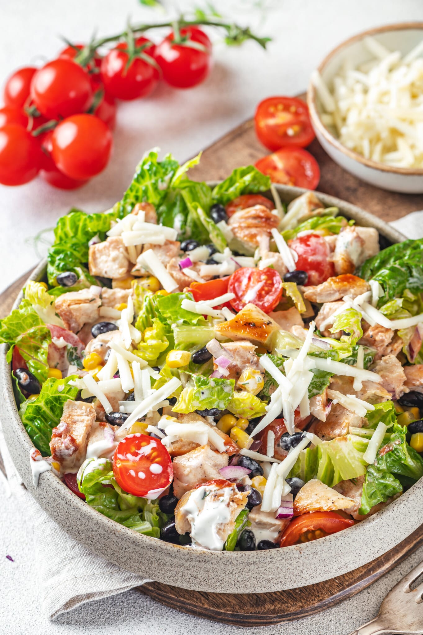 mexican salad with shredded cheese on top in a grey bowl.