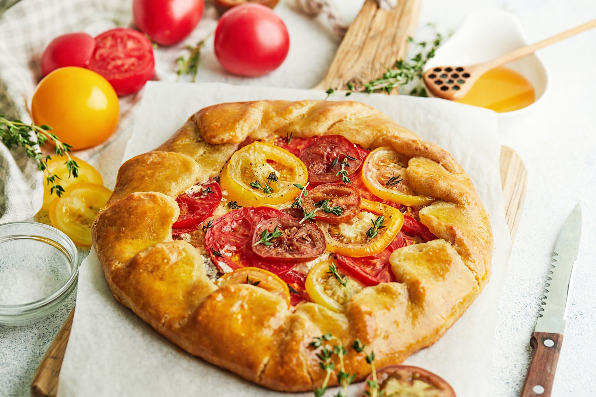 parchment paper with a galette on top with seasonings on top.