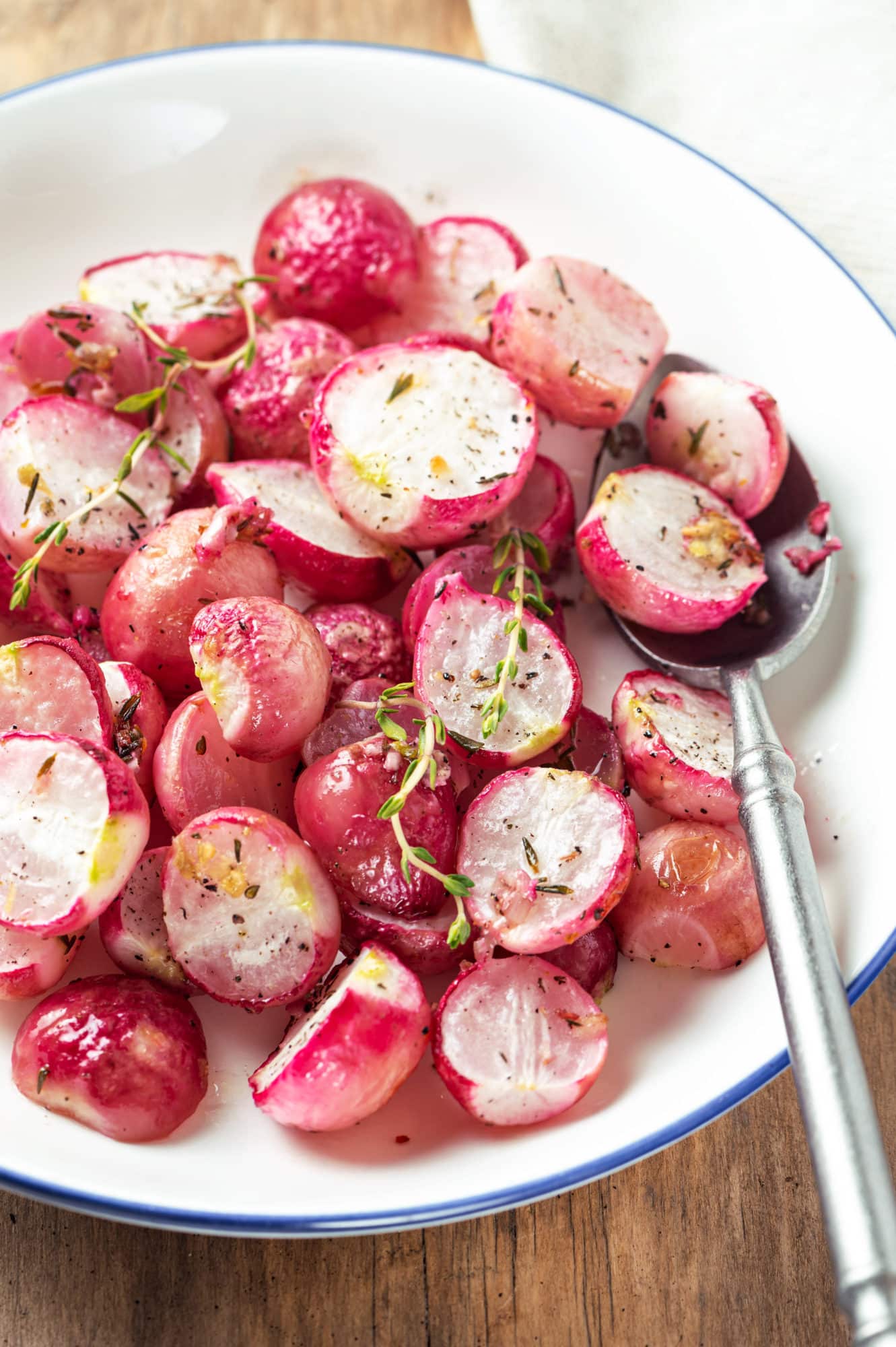 roasted-red-radishes-red-in-a-bowl-with-thyme-and-spoon-whtie-bowl-yum