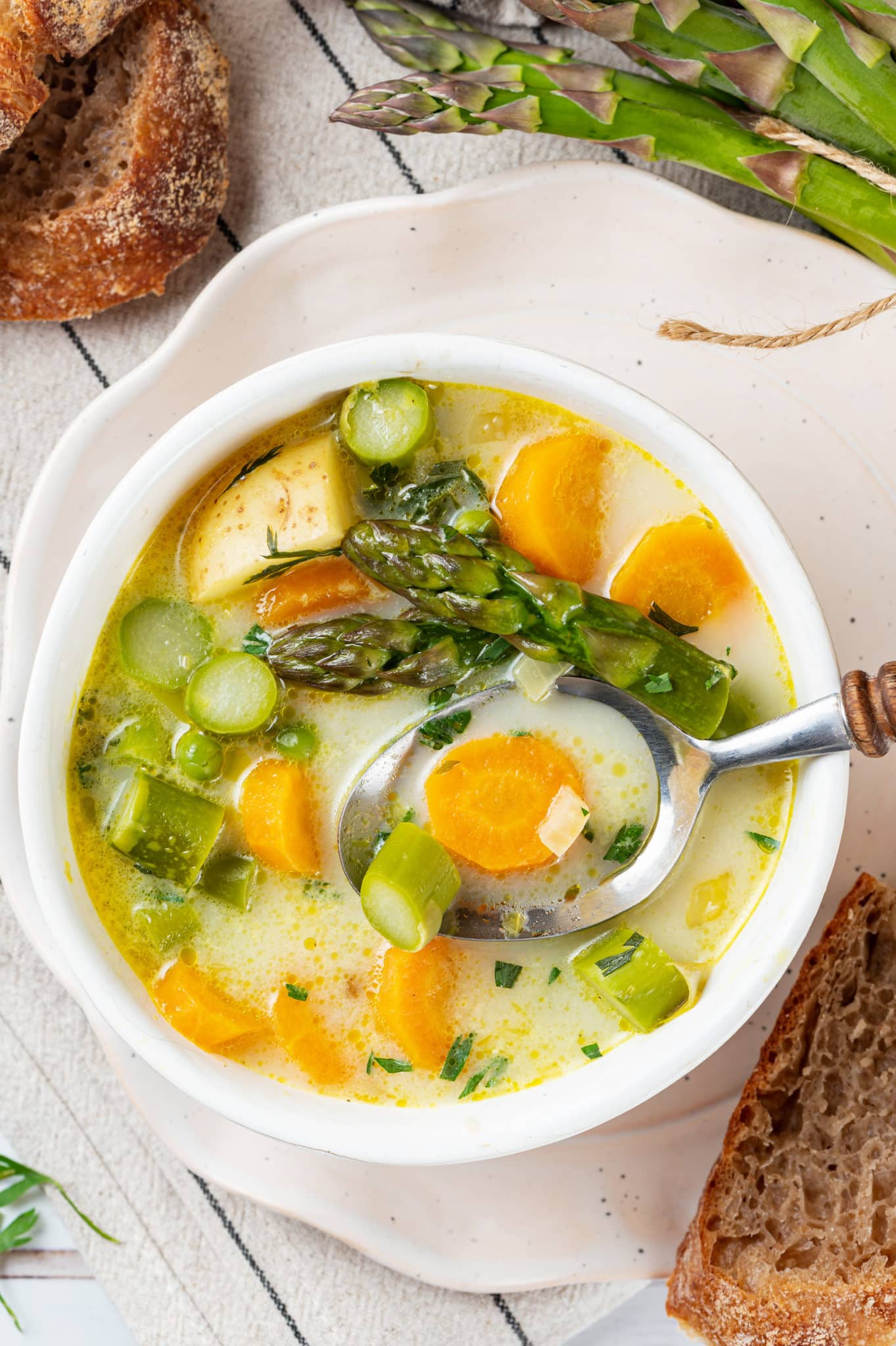 a white bowl of homemade asparagus soup with a spoon