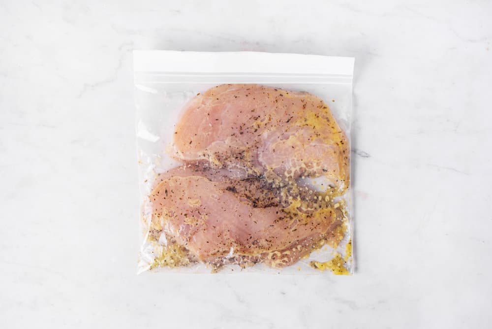 chicken breasts in a plastic bag with marinade.