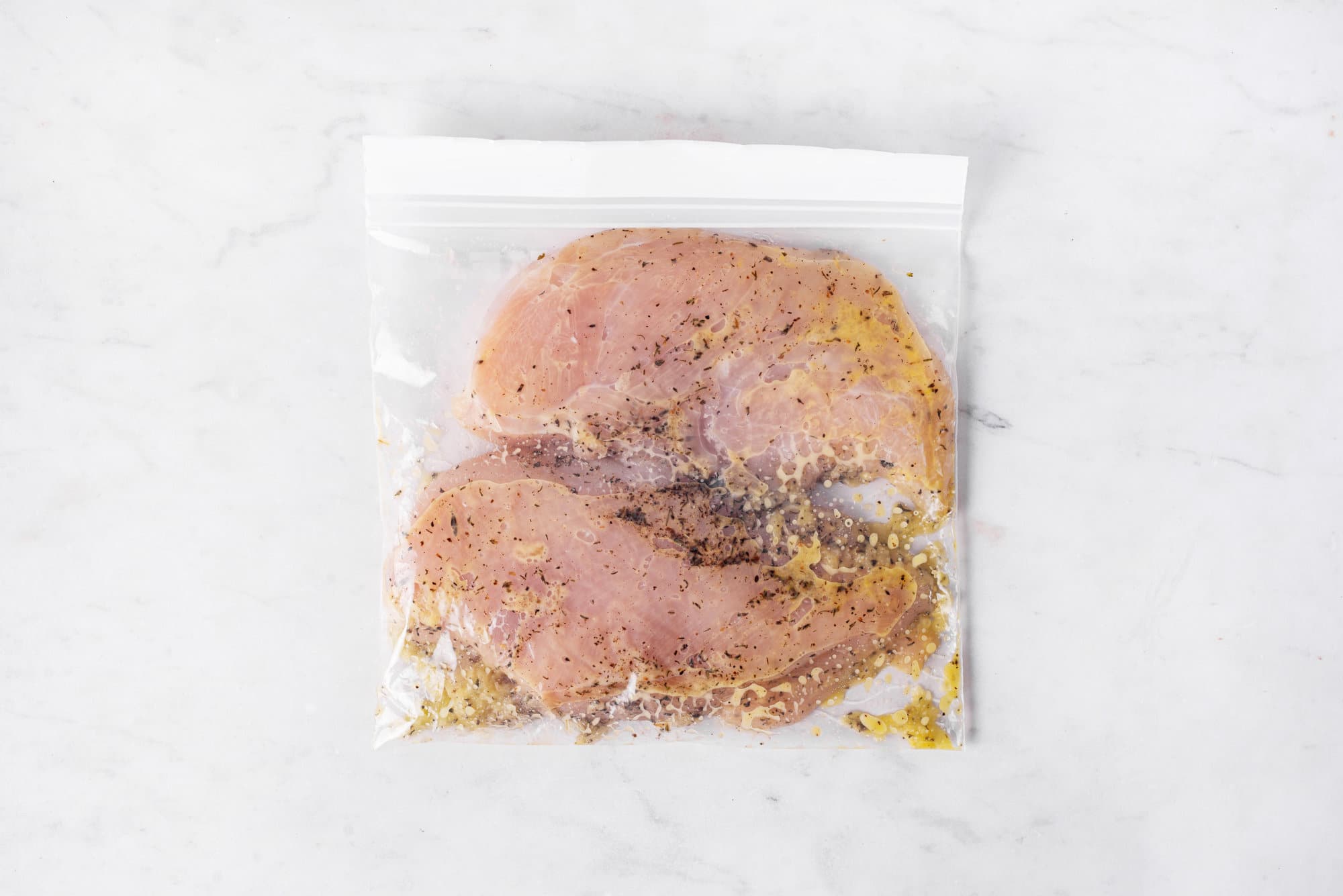 Marinating chicken in a plastic bag.