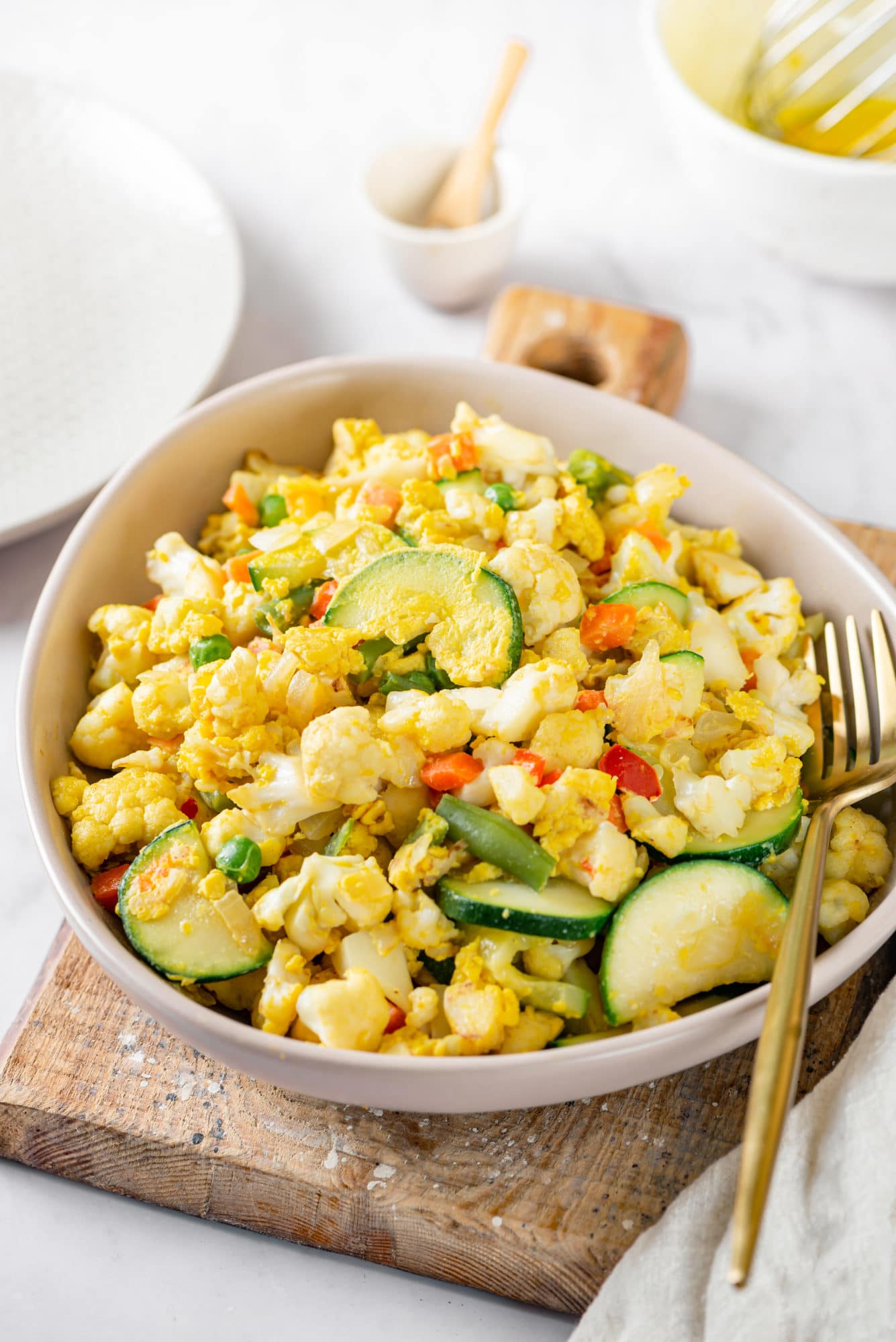 Cauliflower rice in a bowl with a fork on the side.