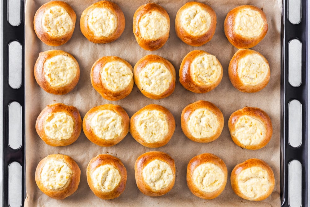 Baked Russian vatrushka buns on a baking tray.