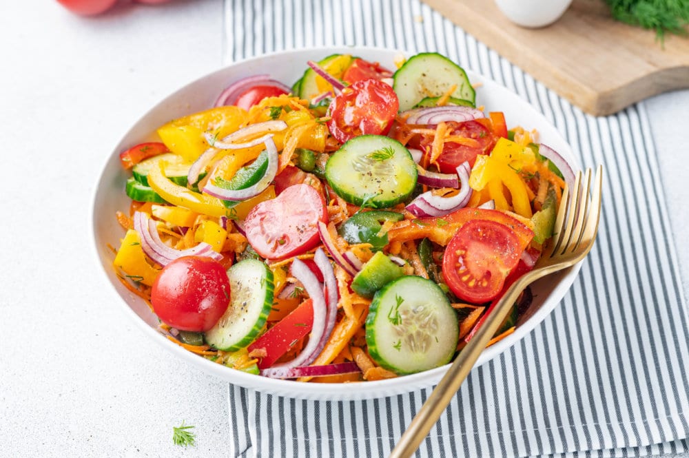 low-carb-clean-eating-veggie-bowl-salad-in-white-bowl-with-towel-and-gold-fork