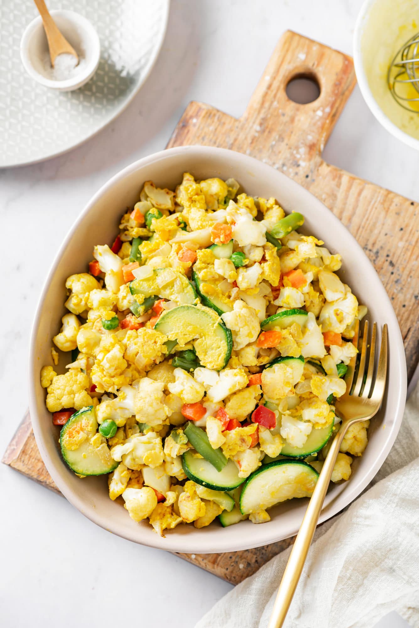 Cauliflower rice in a bowl with a fork on the side.