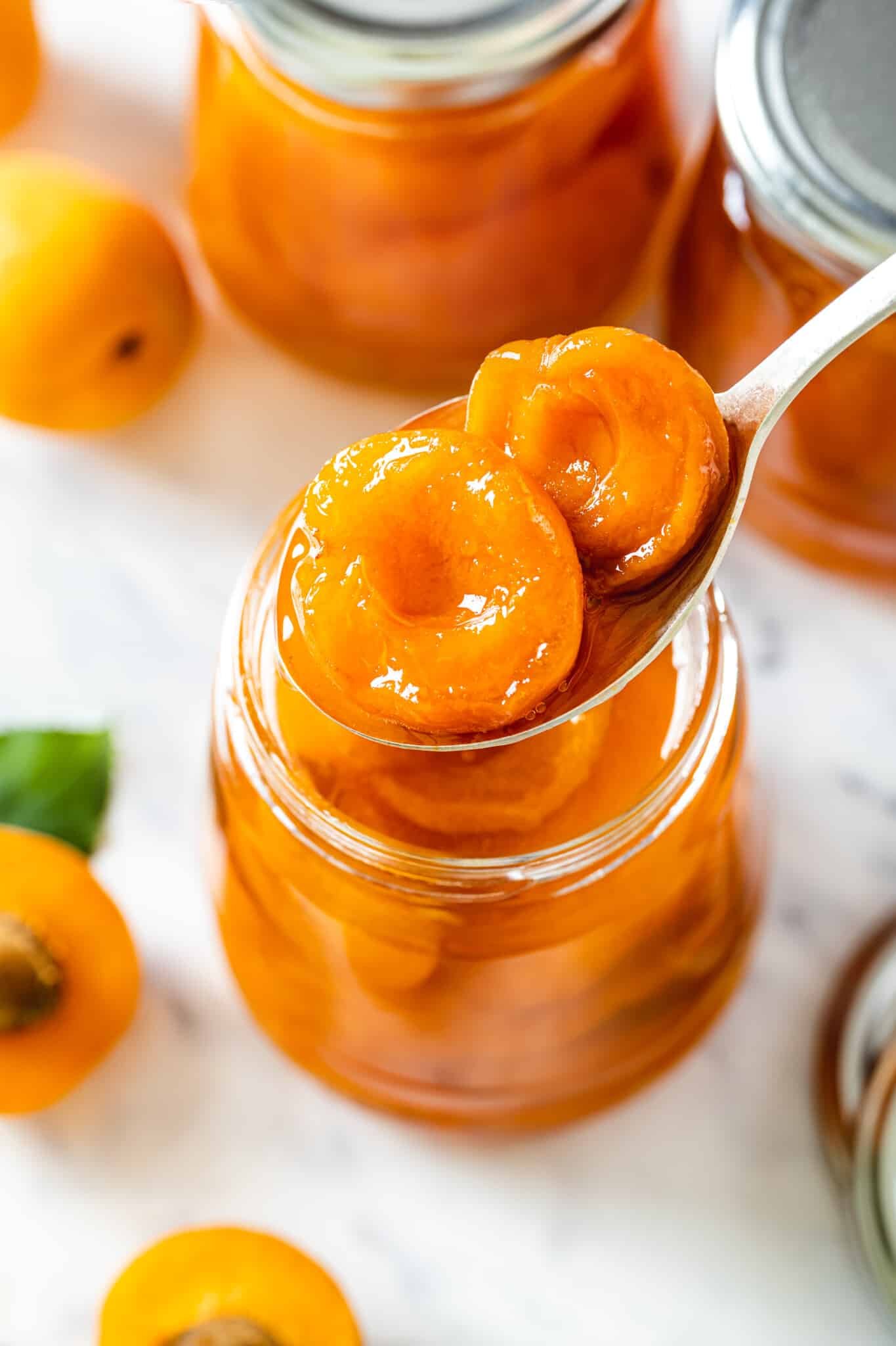 a jar with apricot jam with a spoon.