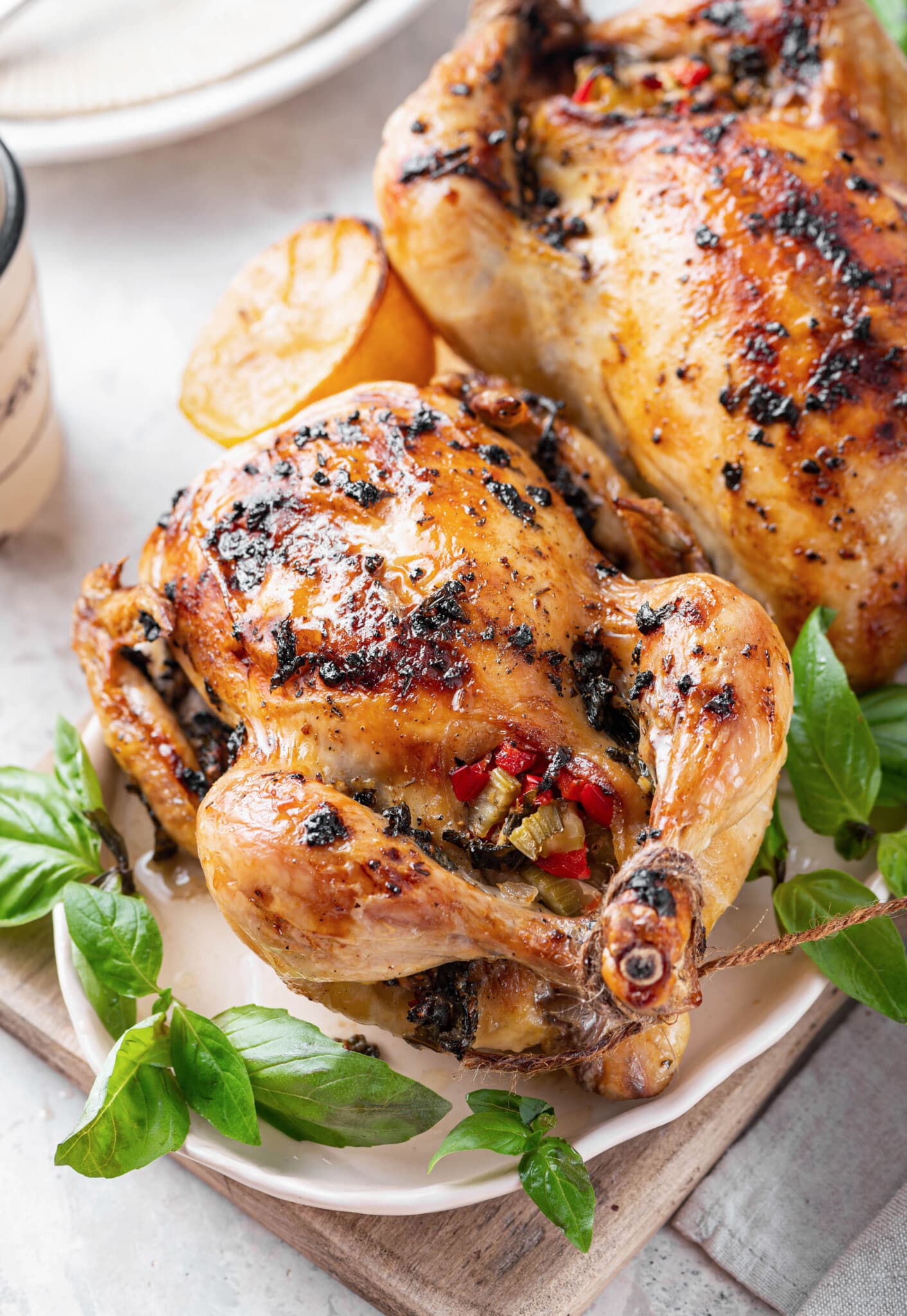 cornish-hens-on-a-white-plate-with-basil-on-a-wooden-board