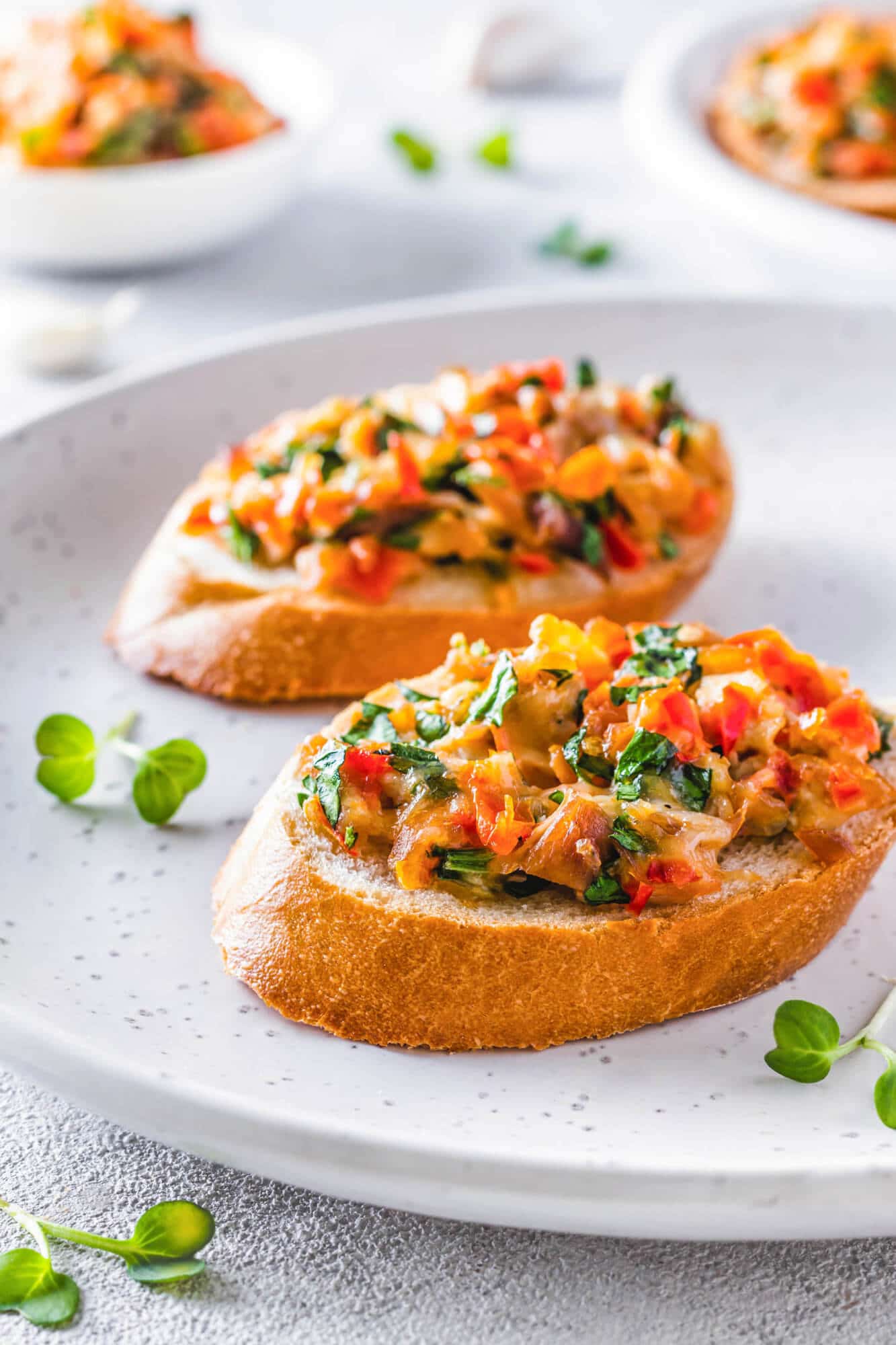 Bruschetta on a white plate with microgreens.