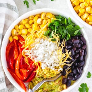 Veggie rice bowl on a towel with a fork and with parsley.