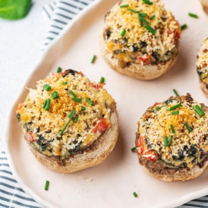 stuffed and baked mushroom caps with cheese and greens chopped on top.