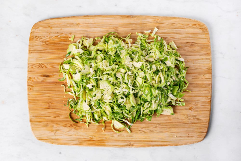 brussels sprouts chopped on a wooden board.