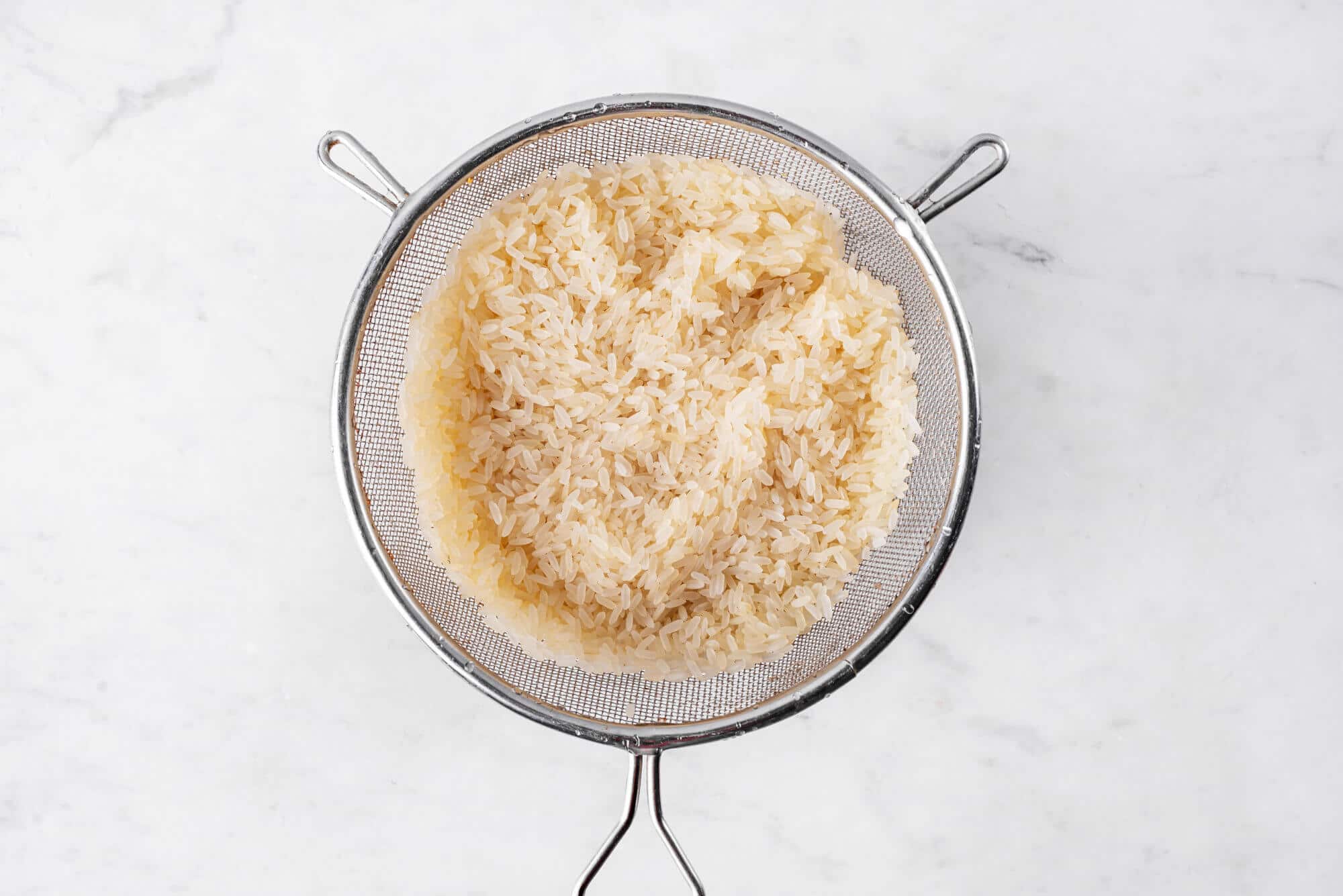 Washed rice in a sieve.