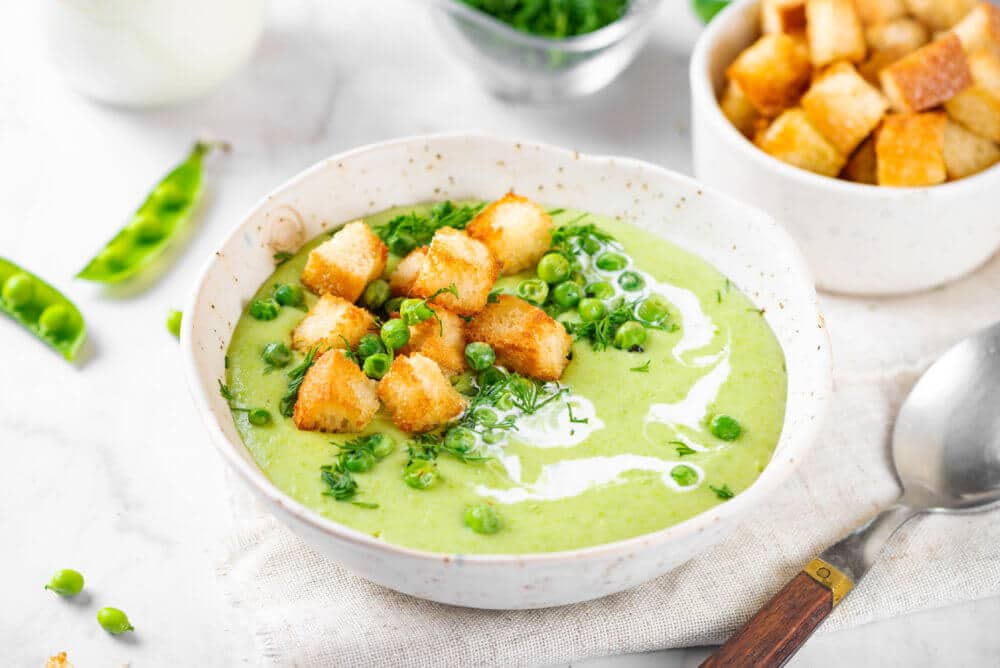 pea soup with cream peas and croutons on top.