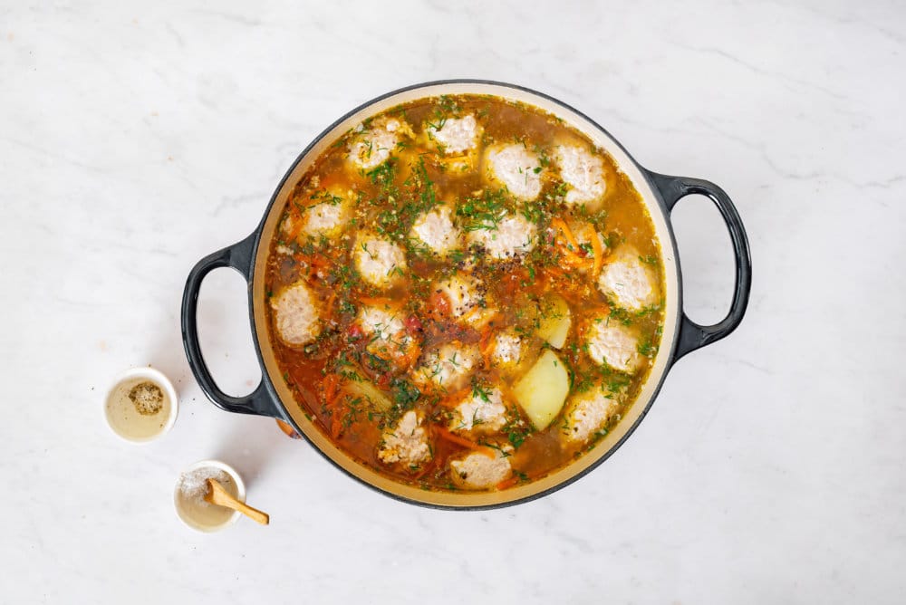 tomato-chicken-soup-in-a-soup-pot-with-salt-and-pepper-bowls-on-the-side