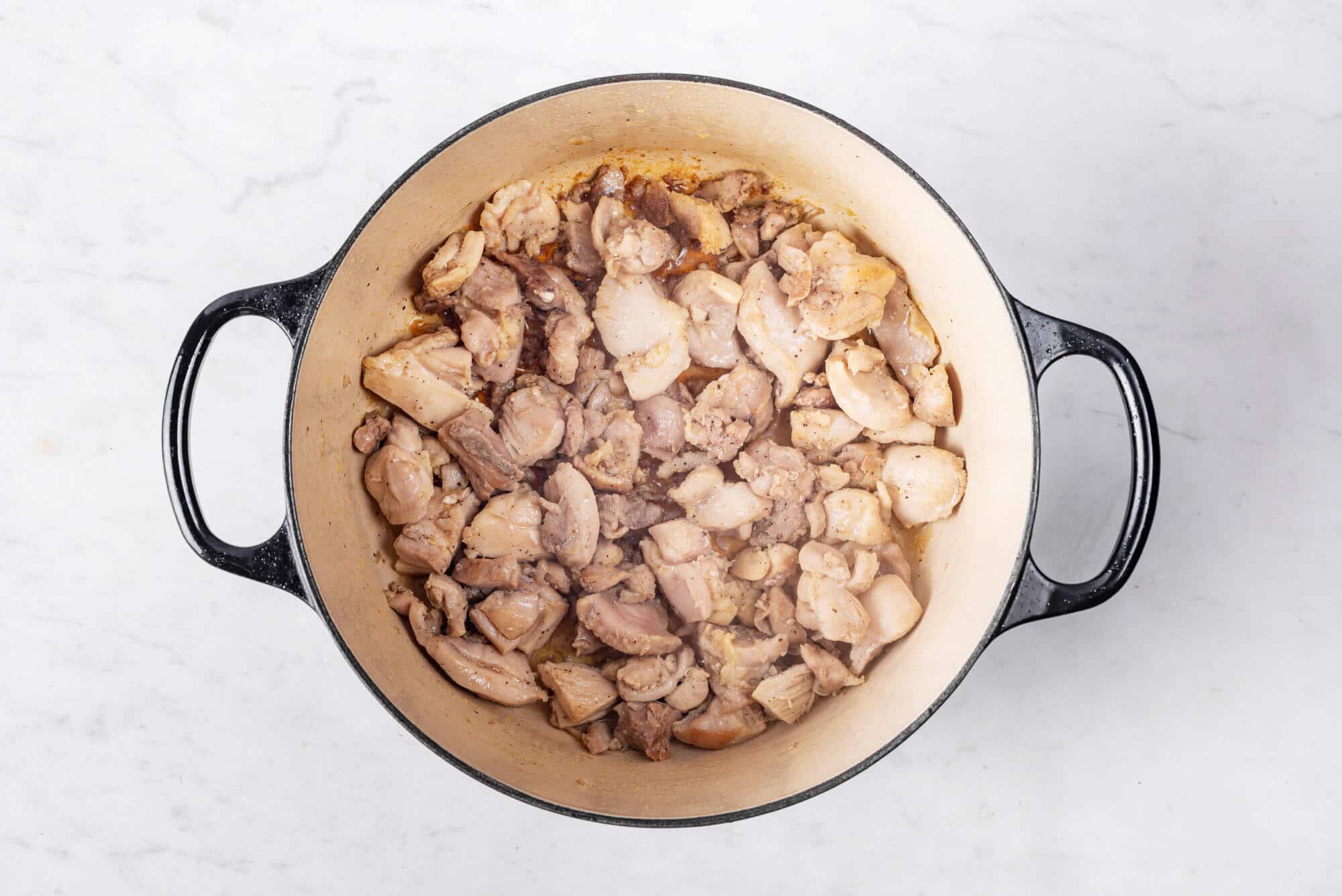 Chicken cooking in a pot.