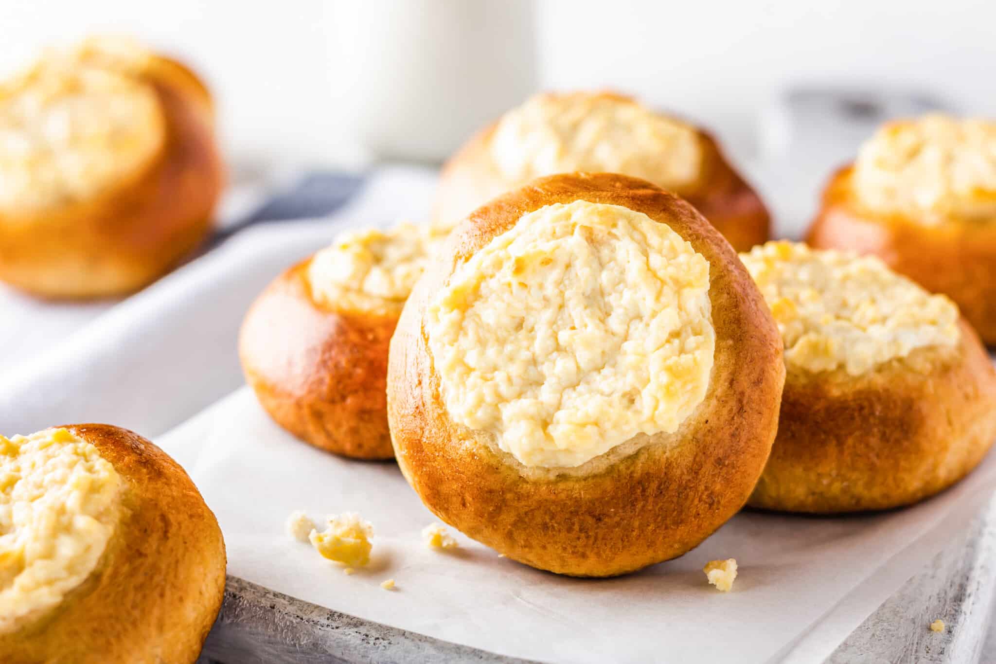 Russian sweet vatrushka buns on parchment paper and a white board.