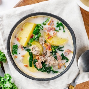 A bowl of toscana on a towel with a spoon.