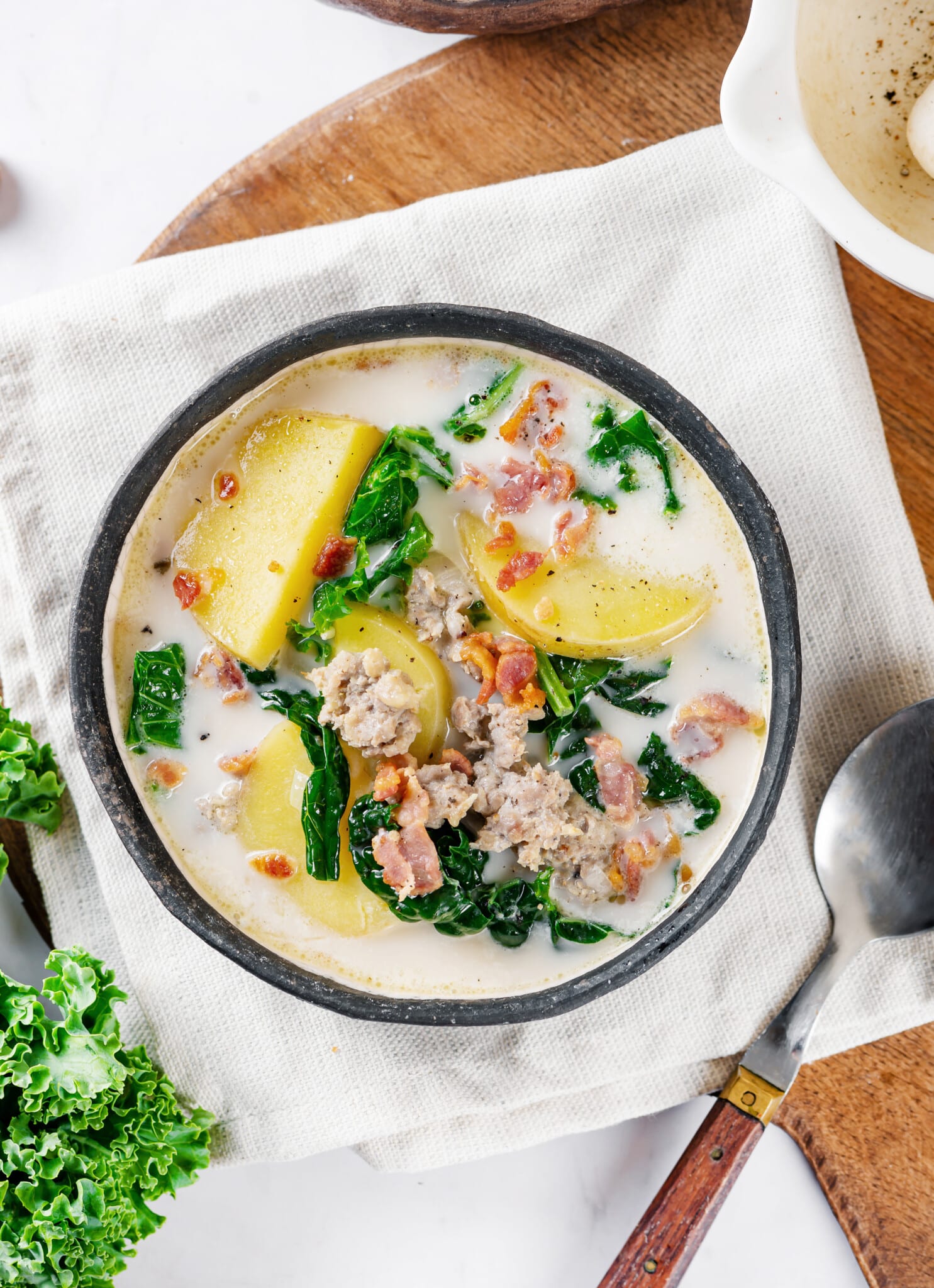 A bowl of toscana on a towel with a spoon.