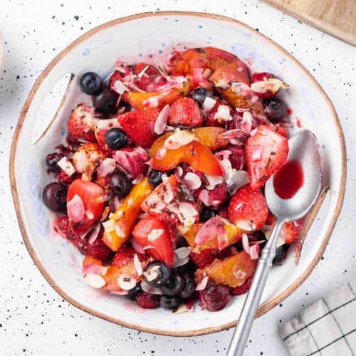 warm fruit salad in a bowl with a spoon.