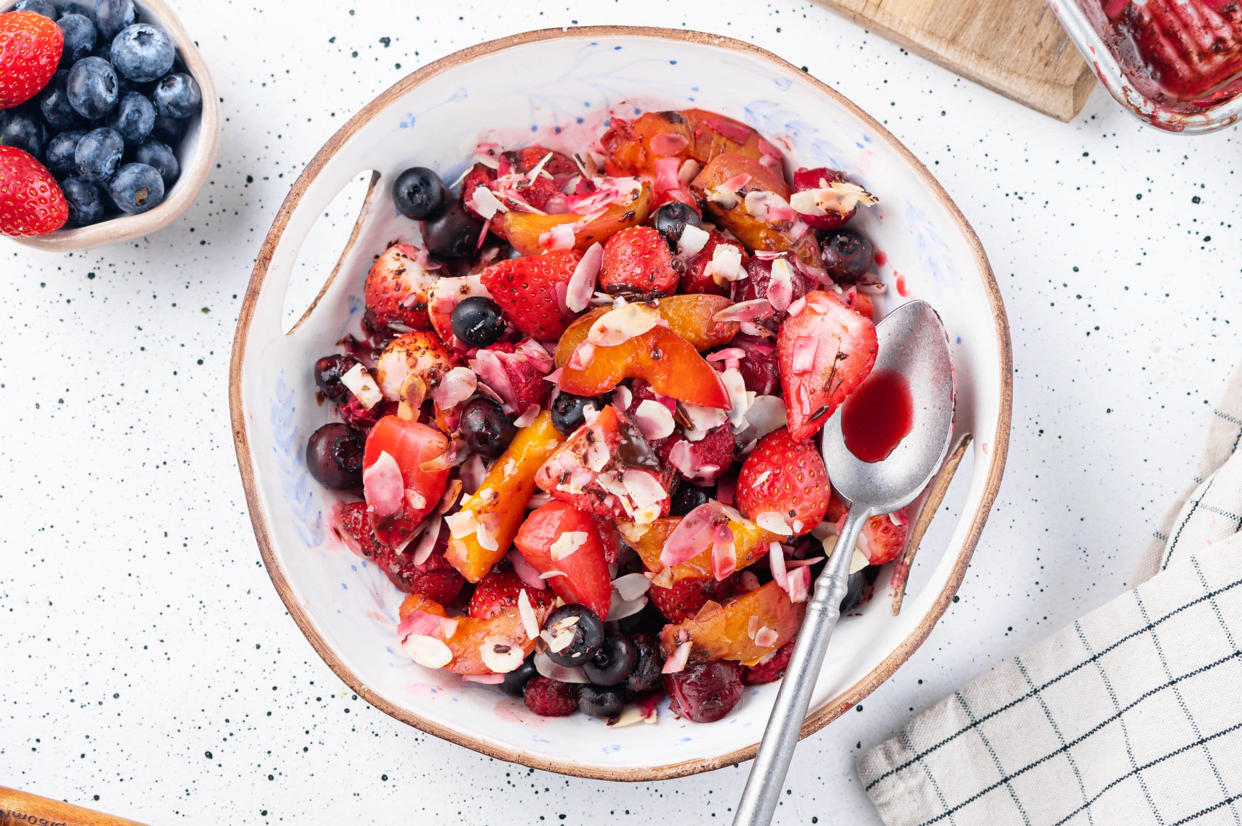 warm fruit salad in a bowl with a spoon.