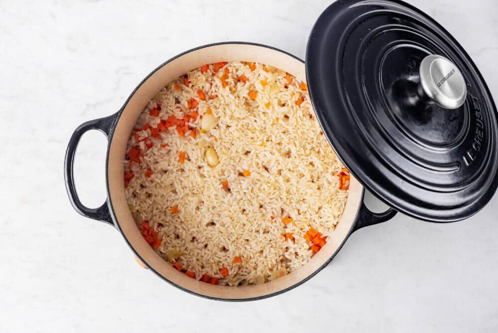 A black pot with a lid with rice pilaf.