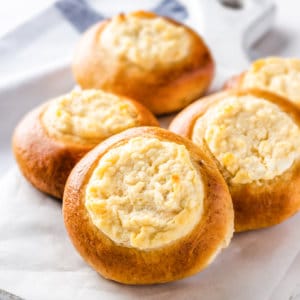 Russian sweet vatrushka buns on parchment paper and a white board.