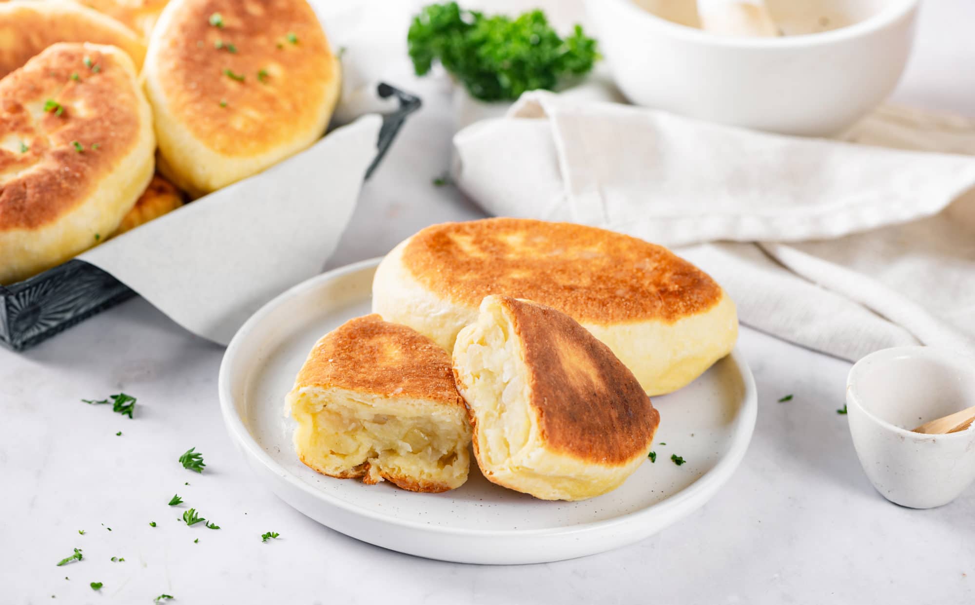 A plate of piroshki with mashed potato filling.