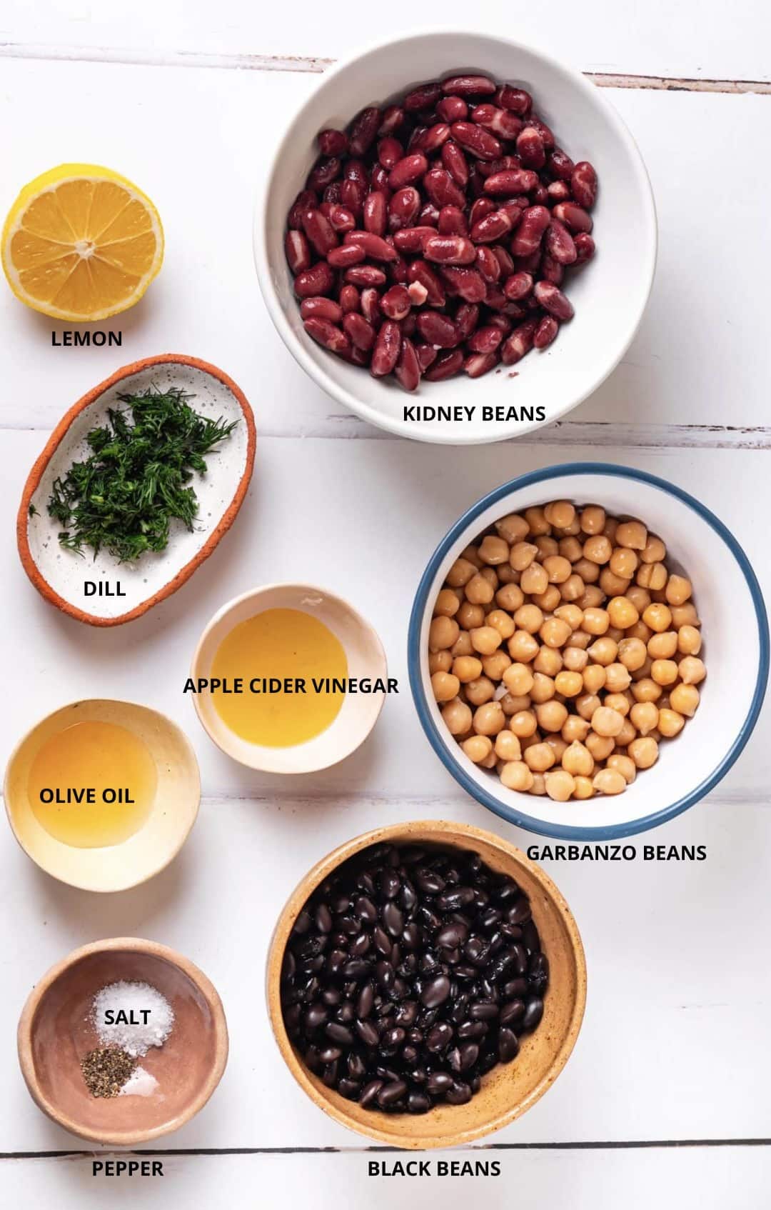 simple and easy bean salad ingredients- kidney beans, lemon, dill, apple cider vinegar, garbanzo beans, black beans, salt, pepper, and olive oil.