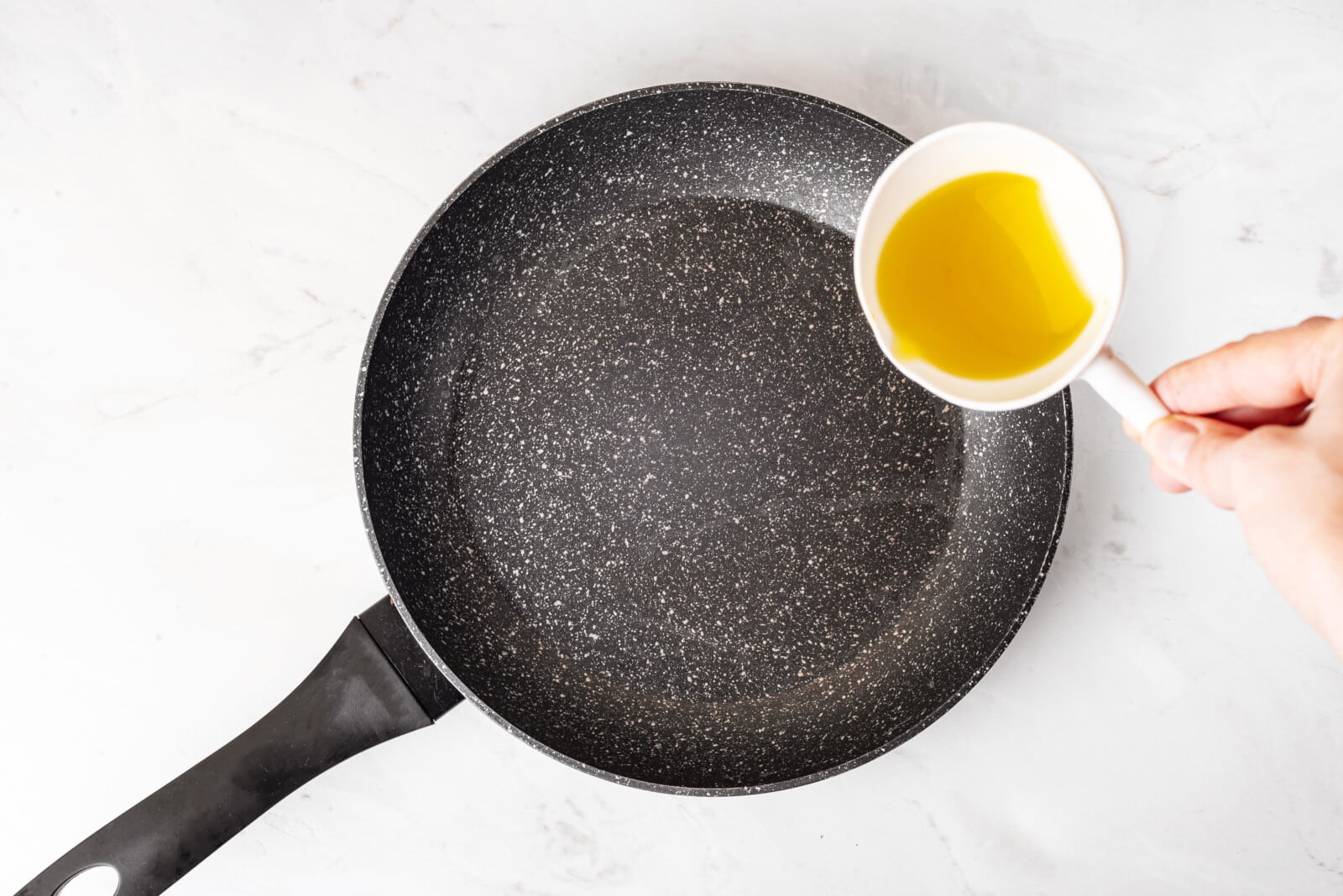 Adding oil to a skillet.