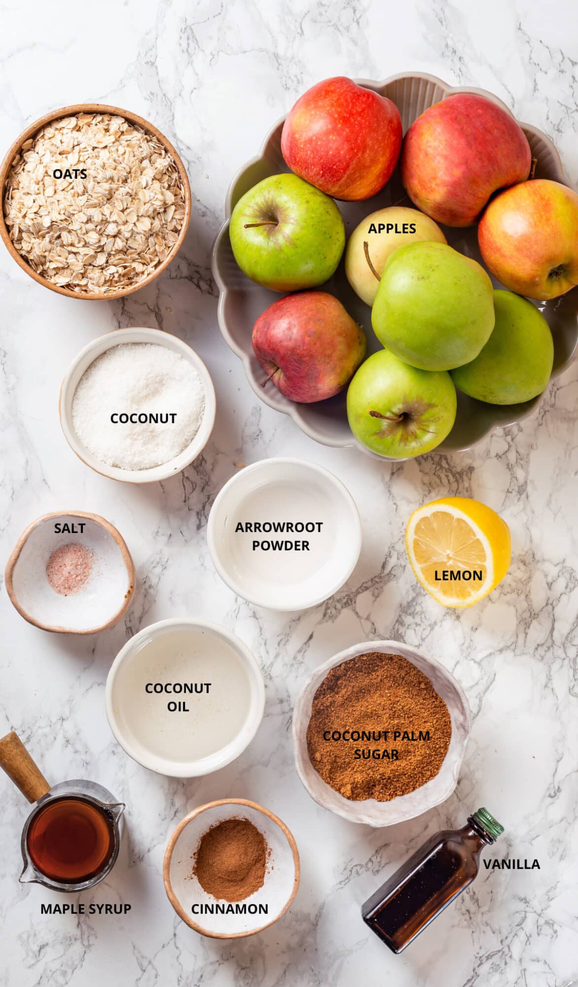 Apple crisp ingredients- arrowroot powder, lemon, apples, oats, coconut, coconut palm sugar, vanilla, cinnamon, maple syrup, coconut oil, and salt.